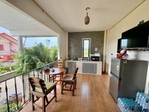 a kitchen with a balcony with a table and chairs at Thai Guesthouse in Kanchanaburi City