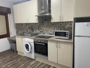 a kitchen with a stove microwave and a refrigerator at Jara y Romero in Ventas con Peña Aguilera