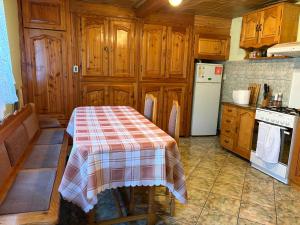 a kitchen with a table with a checkered table cloth at Pensiunea Grapini in Şanţ