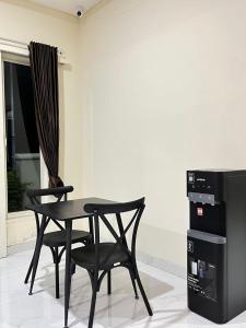 a black table and two chairs in a room at Alya Villa Syariah in Sidoarjo