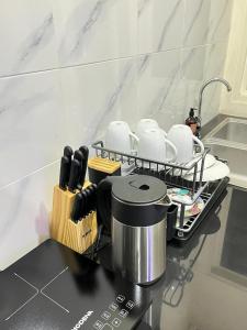 a kitchen with a counter with a coffee pot and utensils at Alya Villa Syariah in Sidoarjo