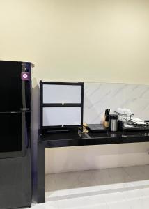 a black desk with a counter top and a refrigerator at Alya Villa Syariah in Sidoarjo