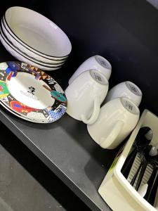 a counter with plates and bowls on a shelf at Alya Villa Syariah in Sidoarjo