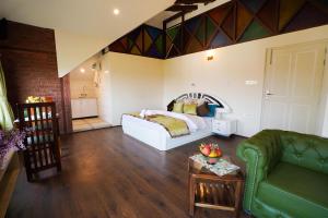 a bedroom with a bed and a couch and a table at Maskan by Rafiqi Estates - Deluxe 2BHK & Studio Apartments in Srinagar