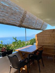 a wooden table and chairs with a view of the ocean at Erika's House in Lukovë