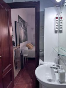 a bathroom with a sink and a bedroom with a bed at Casa Antonio in Benalmádena +4 photos