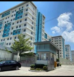 イロイロにあるIloilo Condo near Esplanade & sunset boulevardの大きな建物の前に停車する車