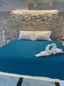 dos cisnes blancos sentados sobre una cama en Giudecca Suite Sea View, en Cefalú