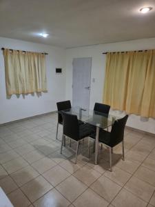 a dining room with a glass table and chairs at Alquiler por día Río Gallegos in Río Gallegos
