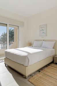 een witte slaapkamer met een groot bed en een raam bij VESTA - Gouna Residence in Hurghada