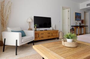 een woonkamer met een tv en een bank en een stoel bij VESTA - Gouna Residence in Hurghada