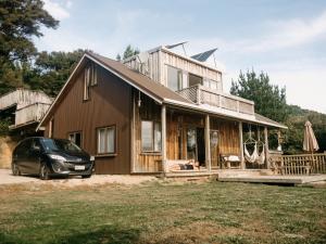 dom z samochodem zaparkowanym przed nim w obiekcie Drift Off Grid w mieście Tata Beach