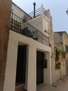 a white building with a balcony and a staircase at Les Terrasses de Choubaka in Alignan-du-Vent