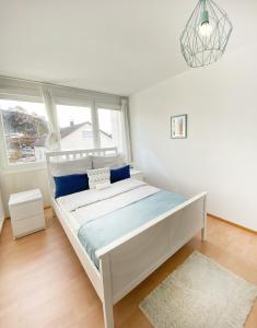 a white bed in a room with a window at Wohnliches Design Apartment in schöner Lage nahe Ulm & Science Park in Blaustein