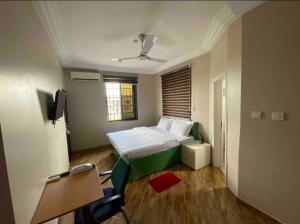 a small room with a bed and a window at The Grange Hotel in Dawhwenya