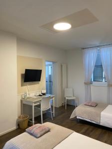 BalernaAlbergo Ristorante Stazione Balerna的一间卧室配有两张床和一张带电脑的书桌