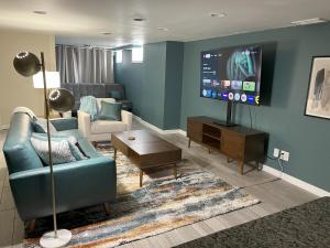 a living room with a couch and a flat screen tv at Ripple Avenue Suites Suite B in Indianapolis