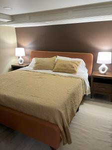 a bedroom with a bed with two lamps on tables at Ripple Avenue Suites Suite B in Indianapolis