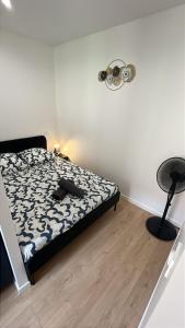 a bedroom with a bed and a black and white comforter at L'appart Lassus climatisation in Montauban