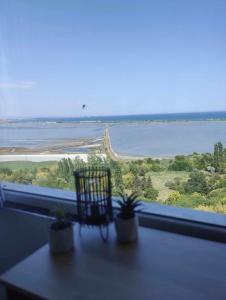 ventana con silla y vistas al agua en Sky Sea Apartment, en Burgas
