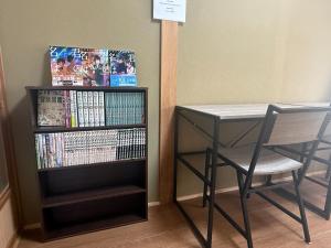 a desk and a table and a book shelf with dvds at Potontoikkenya Kuraoka - Vacation STAY 23373v in Mamihara +9 photos