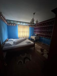 a blue room with a bed and a window at Casa Vlad-Alex in Săpânța +12 photos