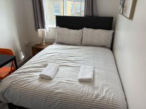 una camera da letto con un letto con due asciugamani sopra di APlaceToStay Premium Central London apartment a Londra