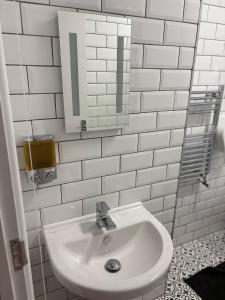 un bagno bianco con lavandino e specchio di APlaceToStay Premium Central London apartment a Londra Altre 3 foto