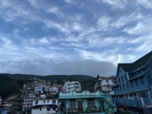 a group of buildings in a city under a cloudy sky at Nya Abode in Shillong