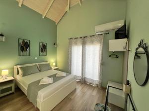 a green bedroom with a bed and a mirror at Ktima Klimentini in Vivari