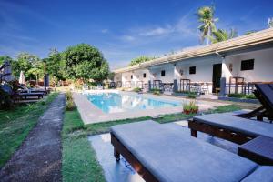 a swimming pool with benches next to a building at Selectum Mangrove Resort in Panglao Island
