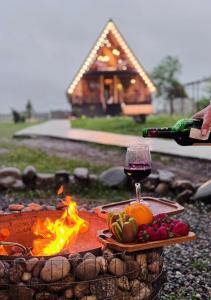 a table with a glass of wine and a plate of fruit at Oda to Didvela -ოდა დიდველაში 