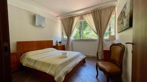 a bedroom with a bed and a chair and a window at Quinta dos Amores in Ponte de Lima +237 photos