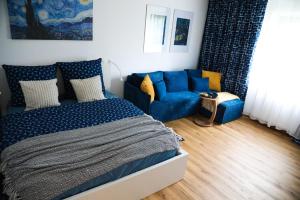 a bedroom with a blue bed and a couch at Suite 13 Van Gogh in Neunburg vorm Wald