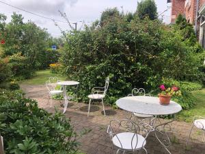 a group of tables and chairs in a garden at Villa Marie SAPHIR in Verton +2 photos