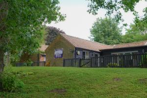 a house with a black fence and a yard at Lakeview at Lodge Farm in Norwich