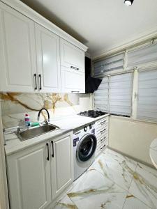 een keuken met een spoelbak en een wasmachine bij home hotel registan in Samarkand
