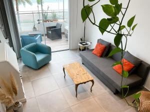 Una sala de estar con un sofá, una silla y una mesa. en La Prom 2 - a two bedroom apartment with a sea view, en Niza