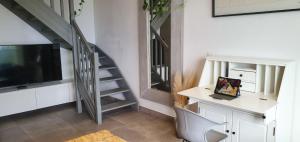 Una sala de estar con una escalera y un televisor. en La Prom 2 - a two bedroom apartment with a sea view, en Niza
