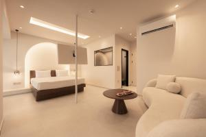 a living room with a bed and a couch and a table at ĪKYMA Boutique in Polychrono +49 photos