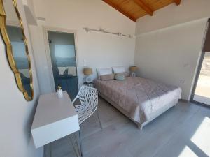 ニドリにあるVilla Ninemiaのベッドとテーブルと鏡のある寝室