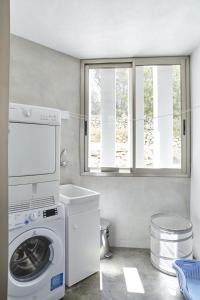eine Waschküche mit einer Waschmaschine und einem Fenster in der Unterkunft Modern 5 Bedroom Villa in Ibiza Haven, 1239 in Sant Antoni de Portmany