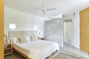 ein weißes Schlafzimmer mit einem Bett und einem Deckenventilator in der Unterkunft Modern 5 Bedroom Villa in Ibiza Haven, 1239 in Sant Antoni de Portmany + 36 Fotos