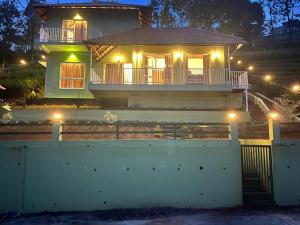 una casa con luces delante de ella por la noche en Green Lushy By Unplugged Vagamon, en Vagamon