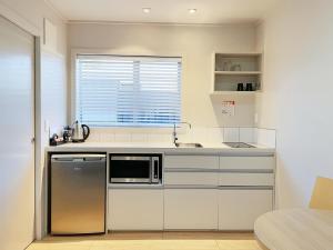 a kitchen with a sink and a microwave at Anchorage Motel Apartments in Te Anau