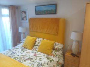 a bedroom with a bed with yellow pillows at 1-Bed Seaside Retreat - Sleeps 2 Parking & Garden in Peacehaven