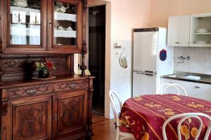 a kitchen with a wooden cabinet with a table and a refrigerator at Casa Editta in Bobbio Pellice