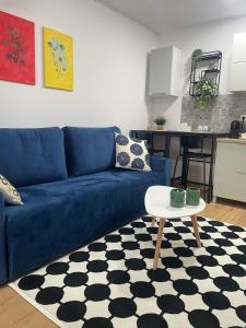 ein blaues Sofa im Wohnzimmer mit einem Tisch in der Unterkunft Apartament Corvin 2 in Hunedoara