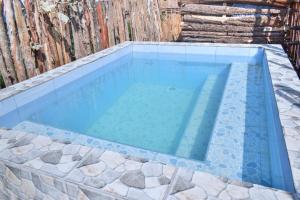 a swimming pool with blue water and rocks at Kaasham Cabin Nanyuki in Nanyuki