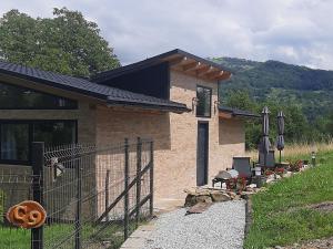 a small house with a fence in front of it at Casa nouă in Vişeu de Sus